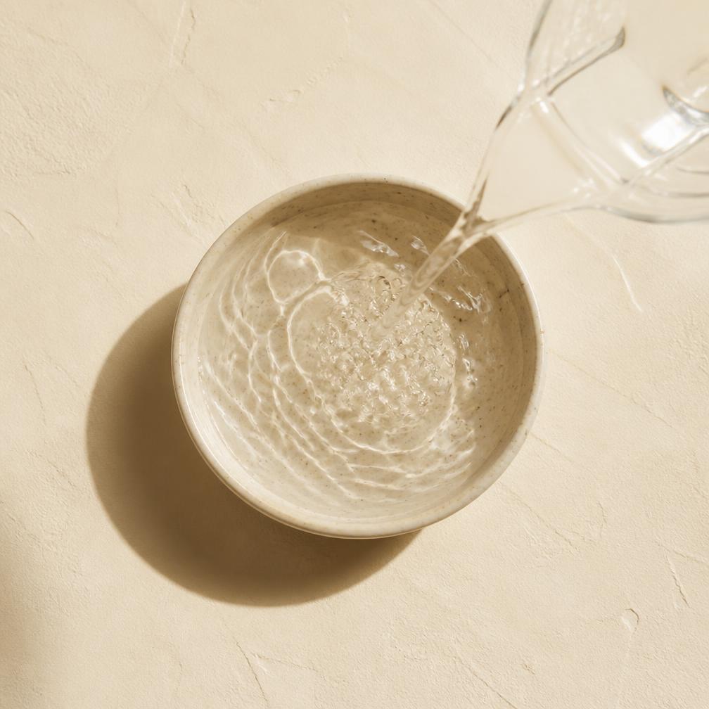 Water being poured into a bowl of powder